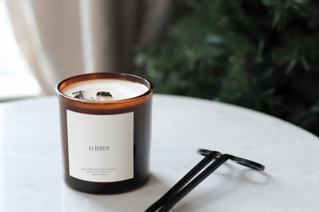 Hand pinching off wood wick tip to remove charred wood before relighting Luceria Candle.