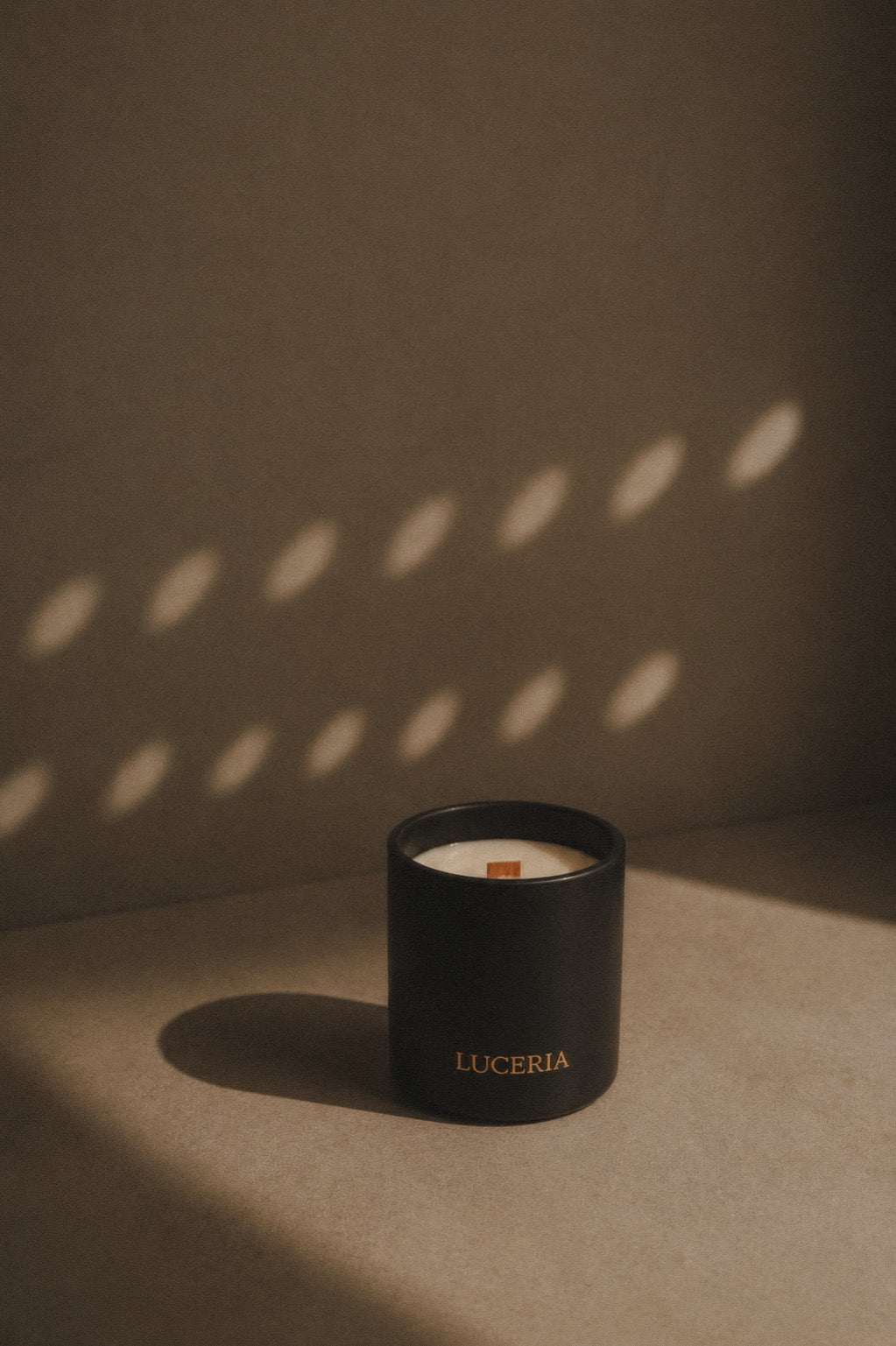 Ritual black matte soy candle with LUCERIA branding in neutral background