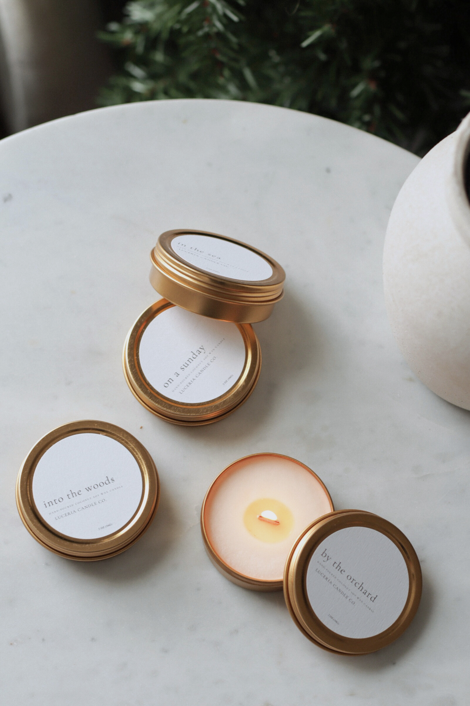 Small candle with gold lid on a marble surface