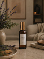 Amber glass Luceria room spray with lavender and cedar fragrance in a calm interior styled with lavender stems, cedar, and neutral décor.