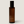 An amber glass bottle with a black cap and gold 'LUCERIA' branding, centered on a light beige background.