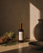 Luceria Redwoods and Moss room spray in an amber glass bottle styled with cedar wood, preserved moss, and warm natural décor.
