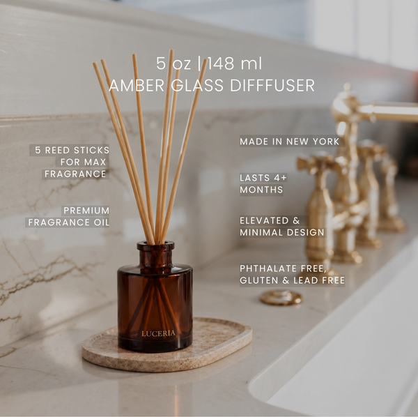 Amber glass Luceria reed diffuser bottle with wooden reed sticks on a marble surface in a bathroom setting, with text overlays detailing product features and specifications.