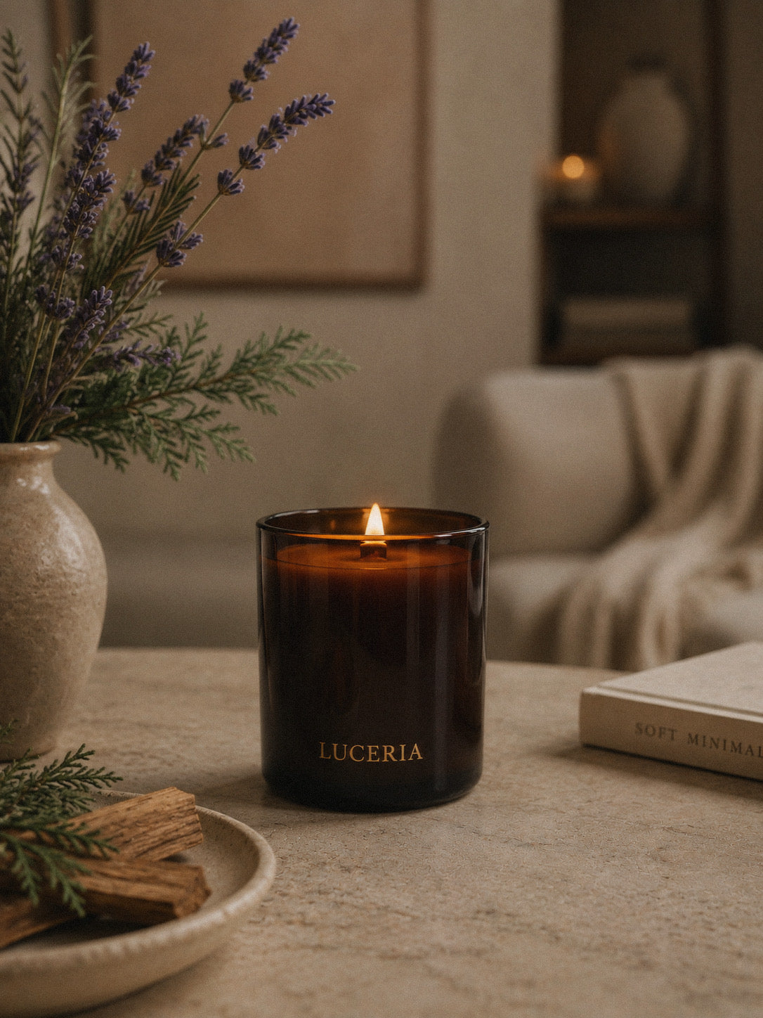 Luceria Lavender and Cedar candle in a amber glass vessel with a natural wood wick, styled in a calm neutral setting inspired by fresh linen and cedar.