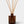 Amber glass reed diffuser bottle with natural wood diffuser sticks, labeled LUCERIA, on a light gray background.