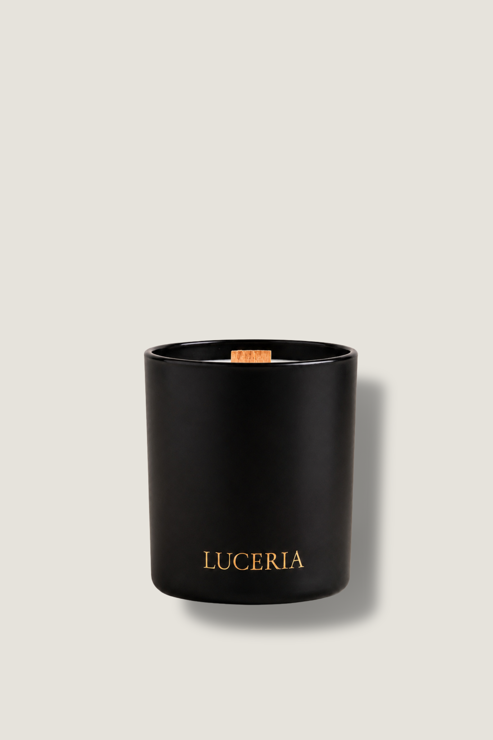 Black candle with 'LUCERIA' branding on a light gray background