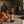 Luceria Persimmon and Peach room spray in an amber glass bottle styled with fresh persimmons, peaches, citrus and warm neutral home décor.