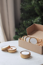 Discovery Set box with gold candle tins by Luceria Candle Co on marble table and greenery.