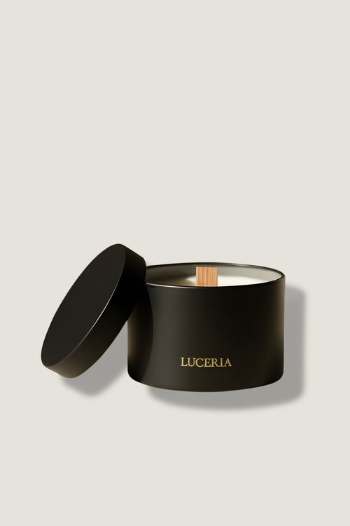 Black candle in a container with 'LUCERIA' branding on a beige background
