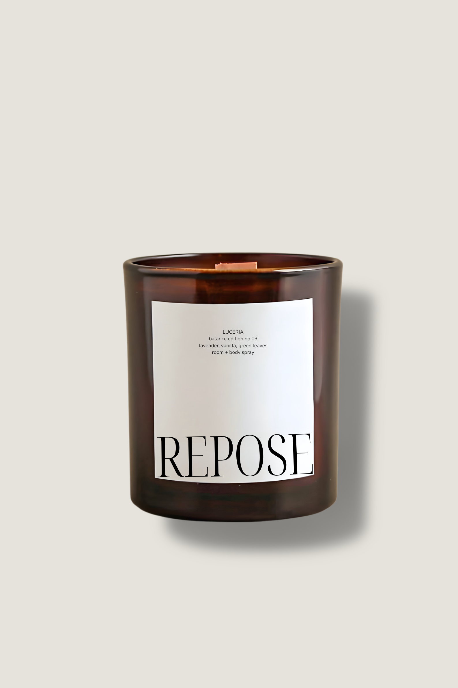 Candle with 'Repose' label on a beige background