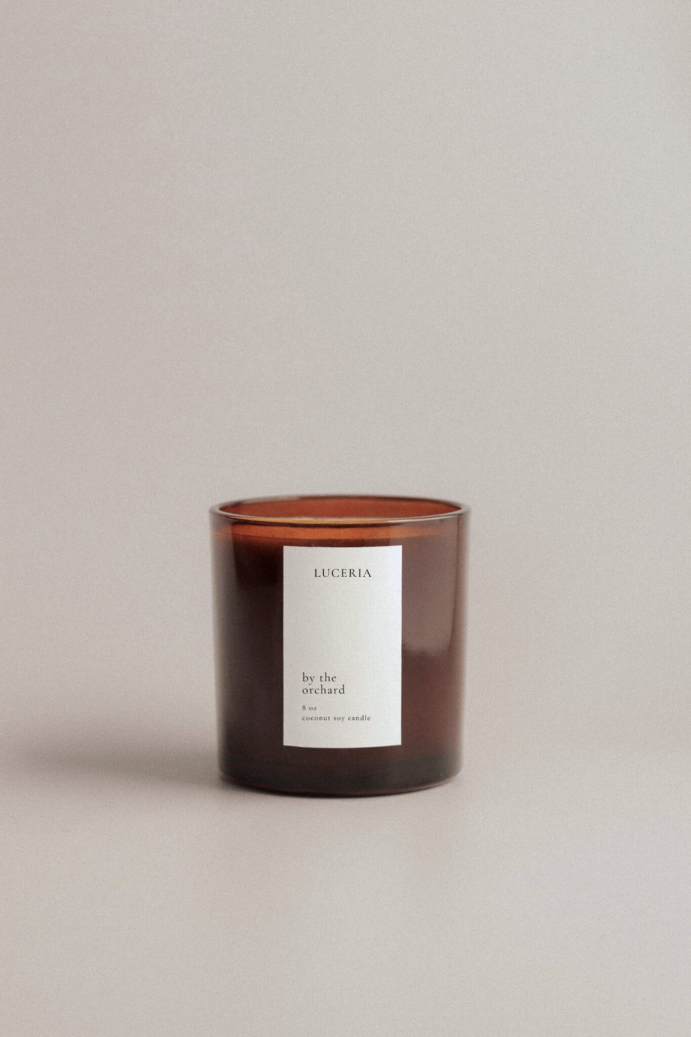 Persimmon Citron scented candle with a white label on a beige background.