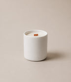 Luceria Candle Co Oakmoss and White Cedar ceramic candle with wood wick labeled ‘LUCERIA’ with white lettering on a neutral beige backdrop with soft diffused lighting.