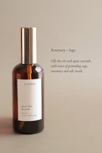 A bottle of Luceria room and body spray labeled 'near the hearth' on a beige background.