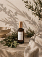 Luceria Candle Co.’s Rosemary and Sage Room and Linen Spray on a neutral background with rosemary sprigs and sage leaves