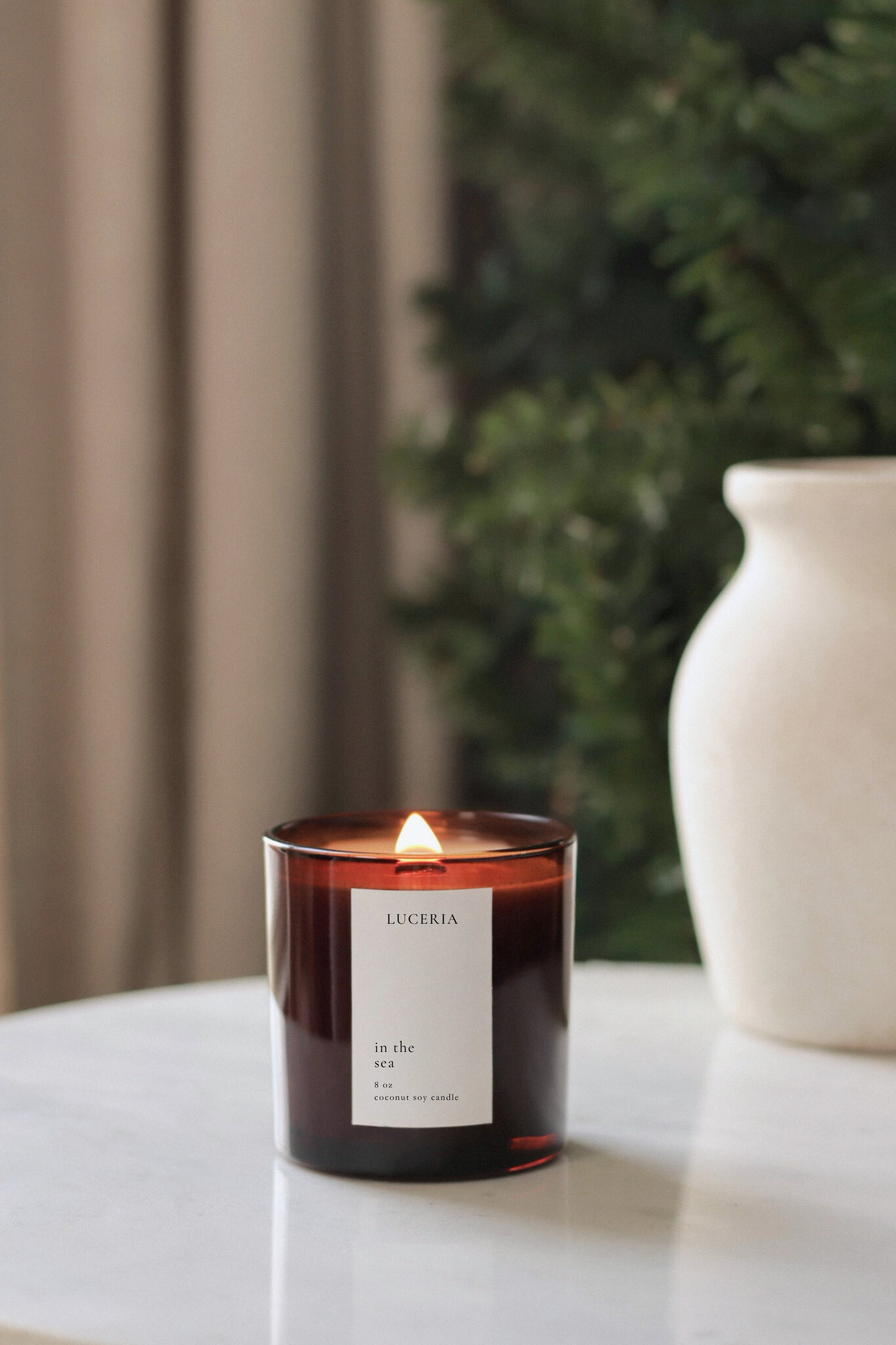 Ocean scented candle with a label on a surface with a blurred background