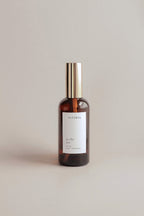 Sea scented brown bottle with gold cap and white label on a light gray background