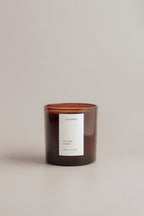 Redwoods and moss scented candle with a label on a beige background