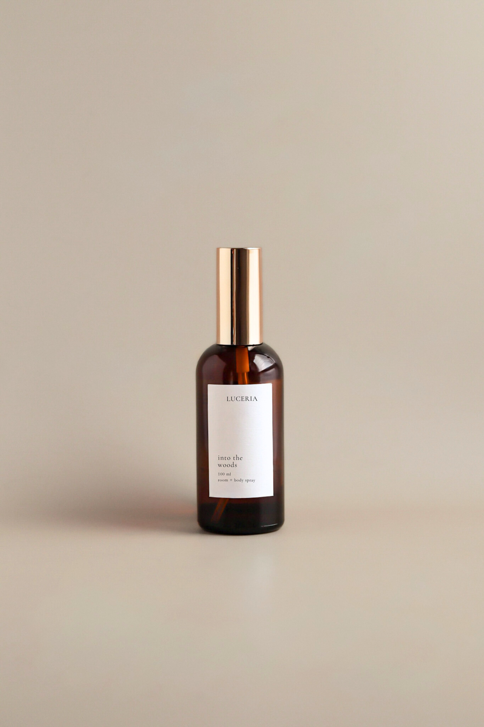 Bottle of Luceria room and body spray product on a beige background