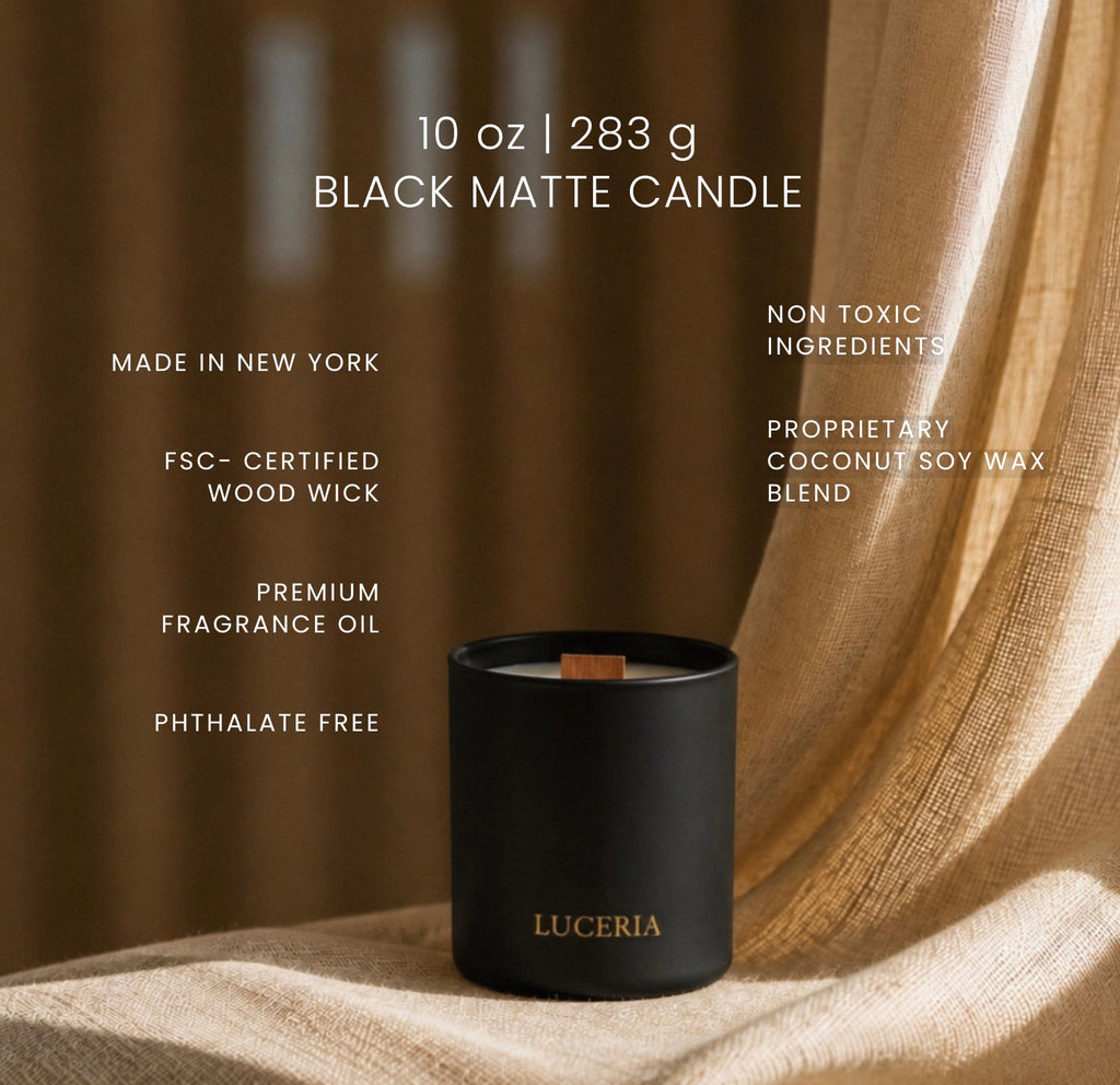 A matte black Luceria candle jar sits on draped beige fabric with warm brown drapery in the background. White text on the image lists product details including 10 oz / 283 g, made in New York, FSC-certified wood wick, premium fragrance oil, and non-toxic ingredients.