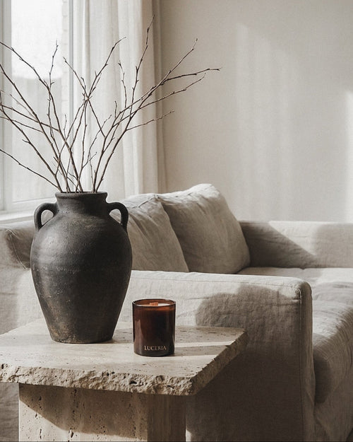 Vase with branches on a stone table in a living room setting