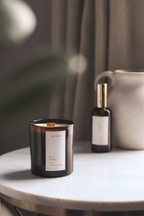 Lavender scented candle and spray bottle on a table with a blurred background