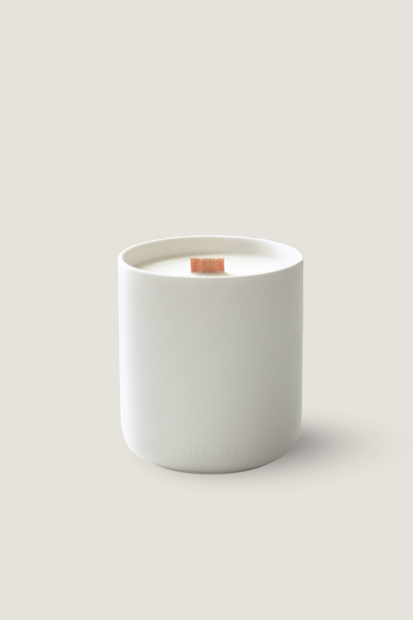 A minimalist white ceramic candle jar labeled 'LUCERIA' with a single wick on top, set against a solid light beige background. Luceria's Oakmoss and White Cedar Candle.