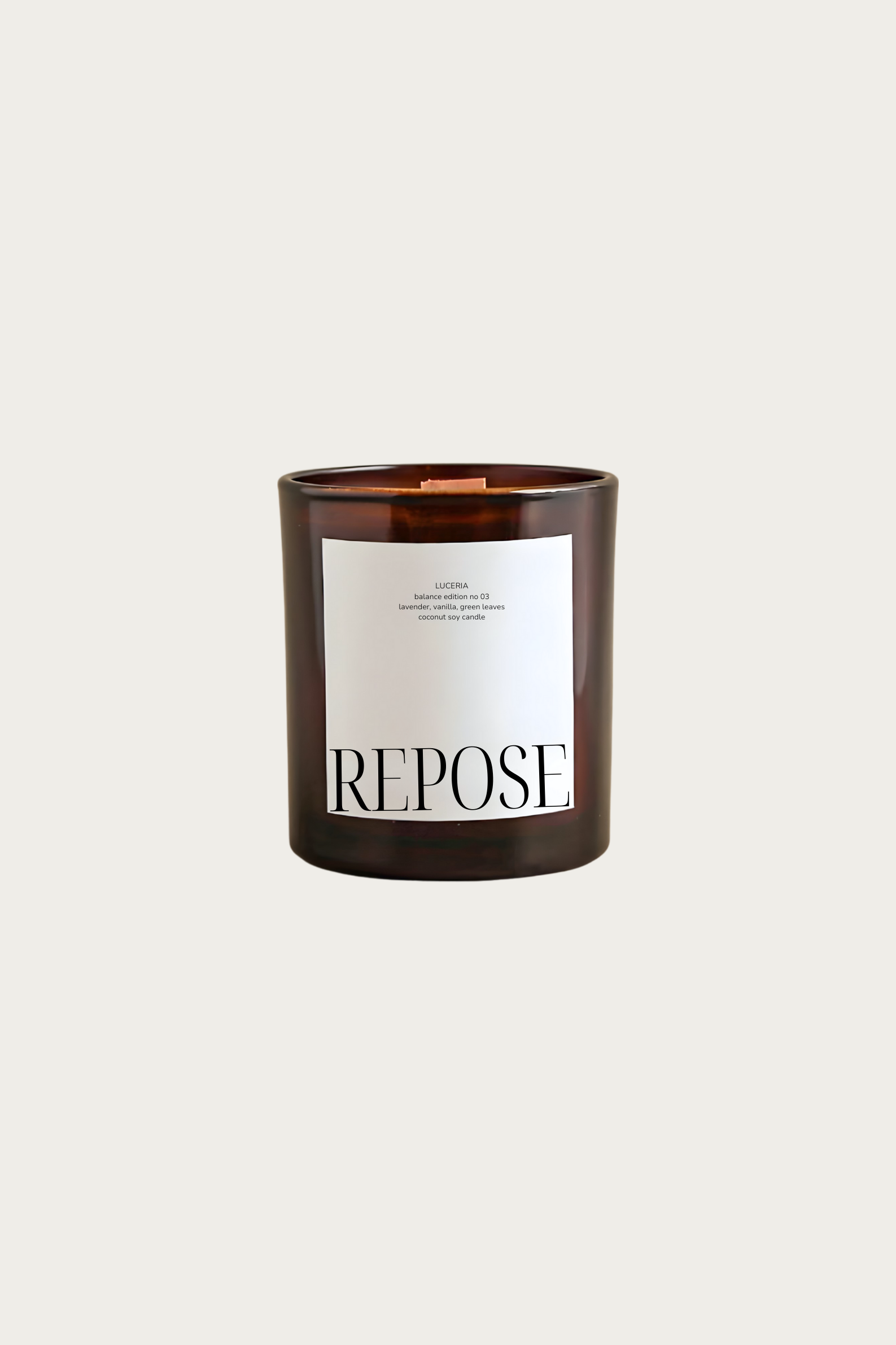 Candle with 'Repose' label on a light beige background