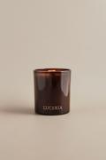 Brown candle with 'LUCERIA' branding on a beige background