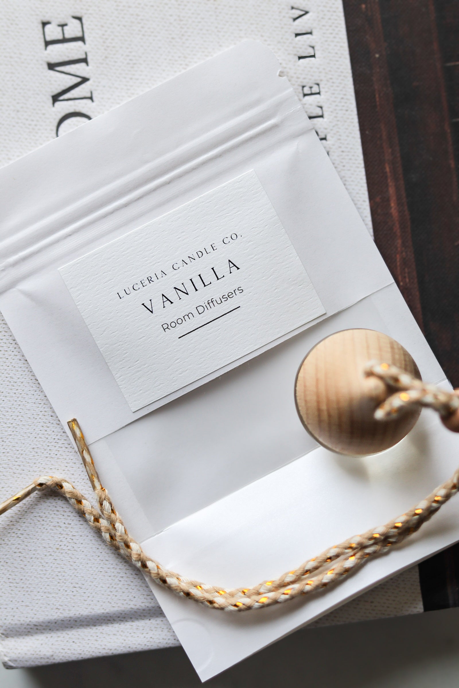 Scented car freshener with wooden diffuser on a textured surface.