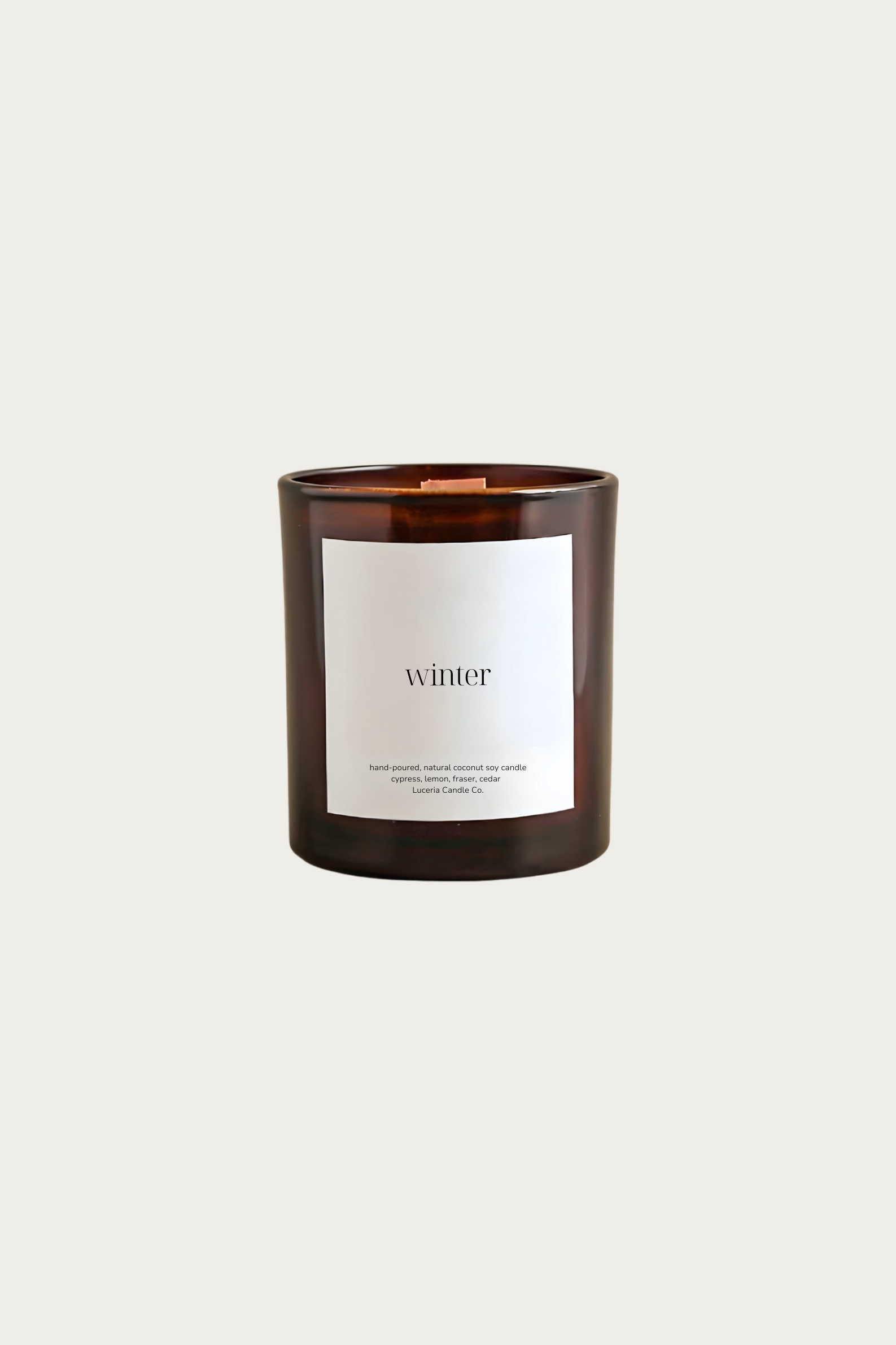 Candle with a label reading 'winter' on a light beige background