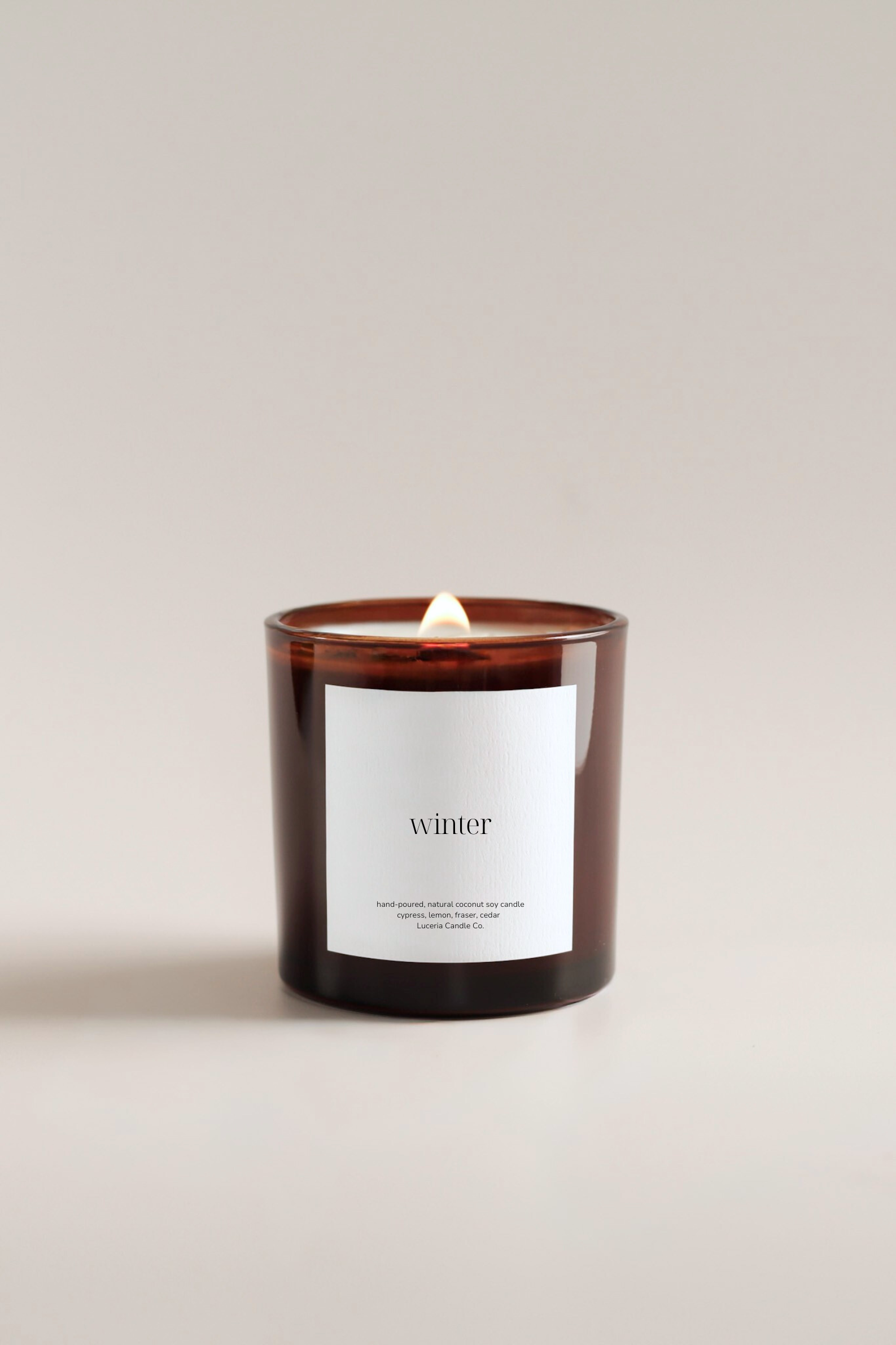 Fraser fir scented candle with a label reading 'winter' on a plain background