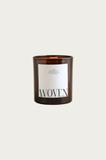 Candle with 'Woven' label on a light beige background