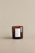 Brown amber candle with Luceria By the Orchard label on a beige background