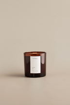 Brown amber candle with a In the Sea label on a beige background by Luceria