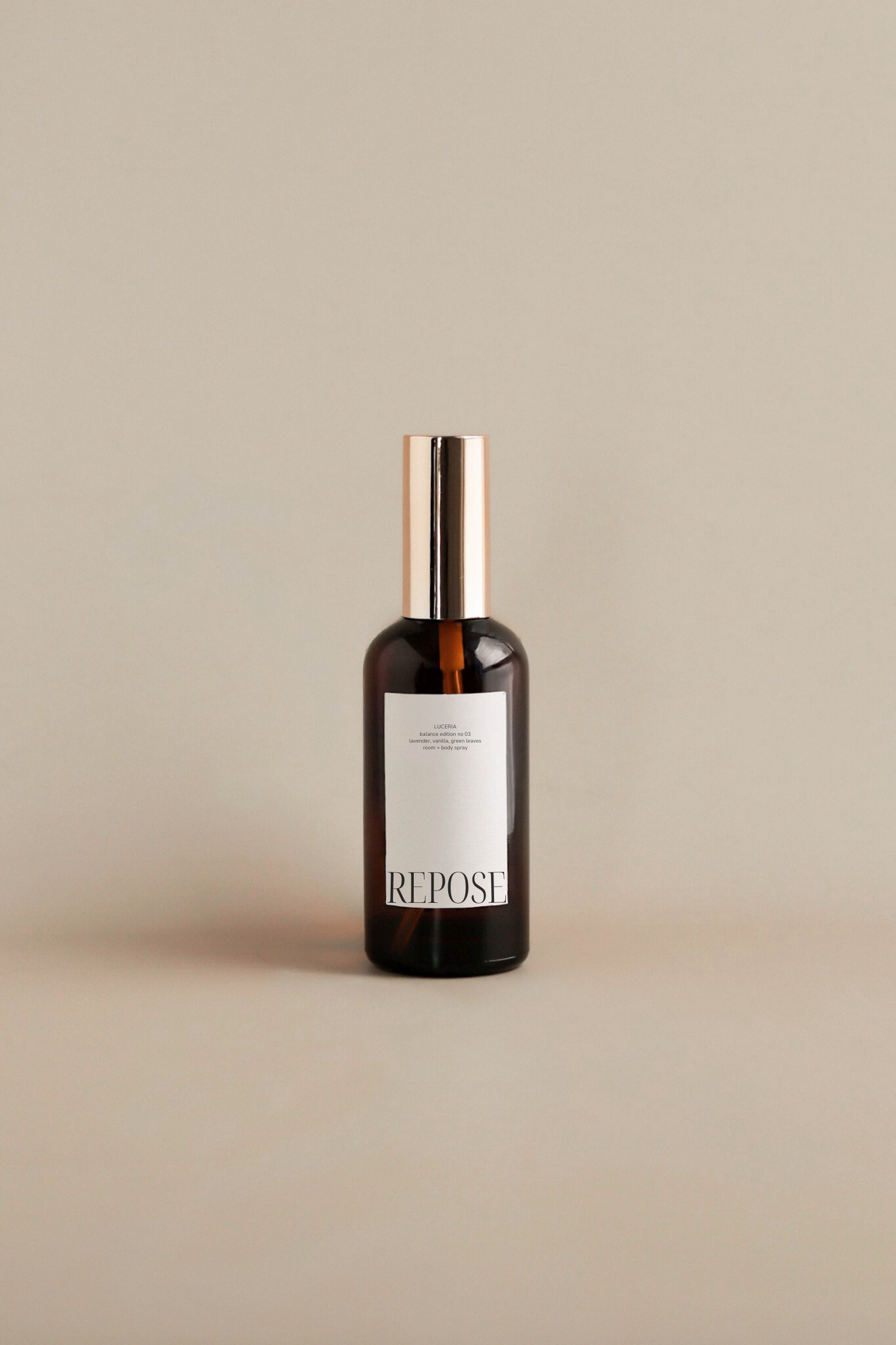 Lavender vanilla scented room and body spray amber bottle on a beige background