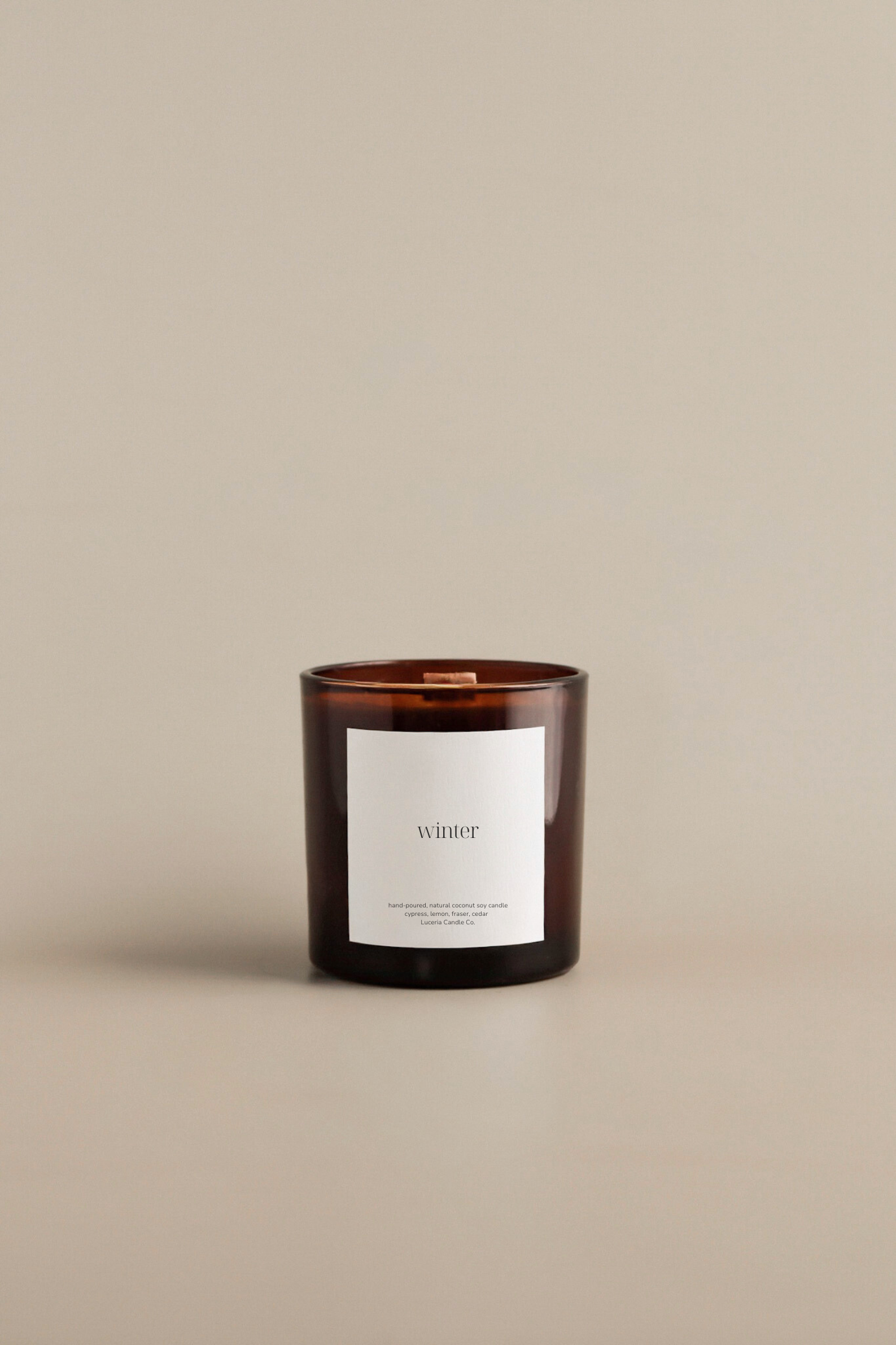 Fraser fir scented candle with a minimalist label on a beige background by Luceria