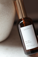 Brown spray bottle with 'LUCERIA' label on a neutral background