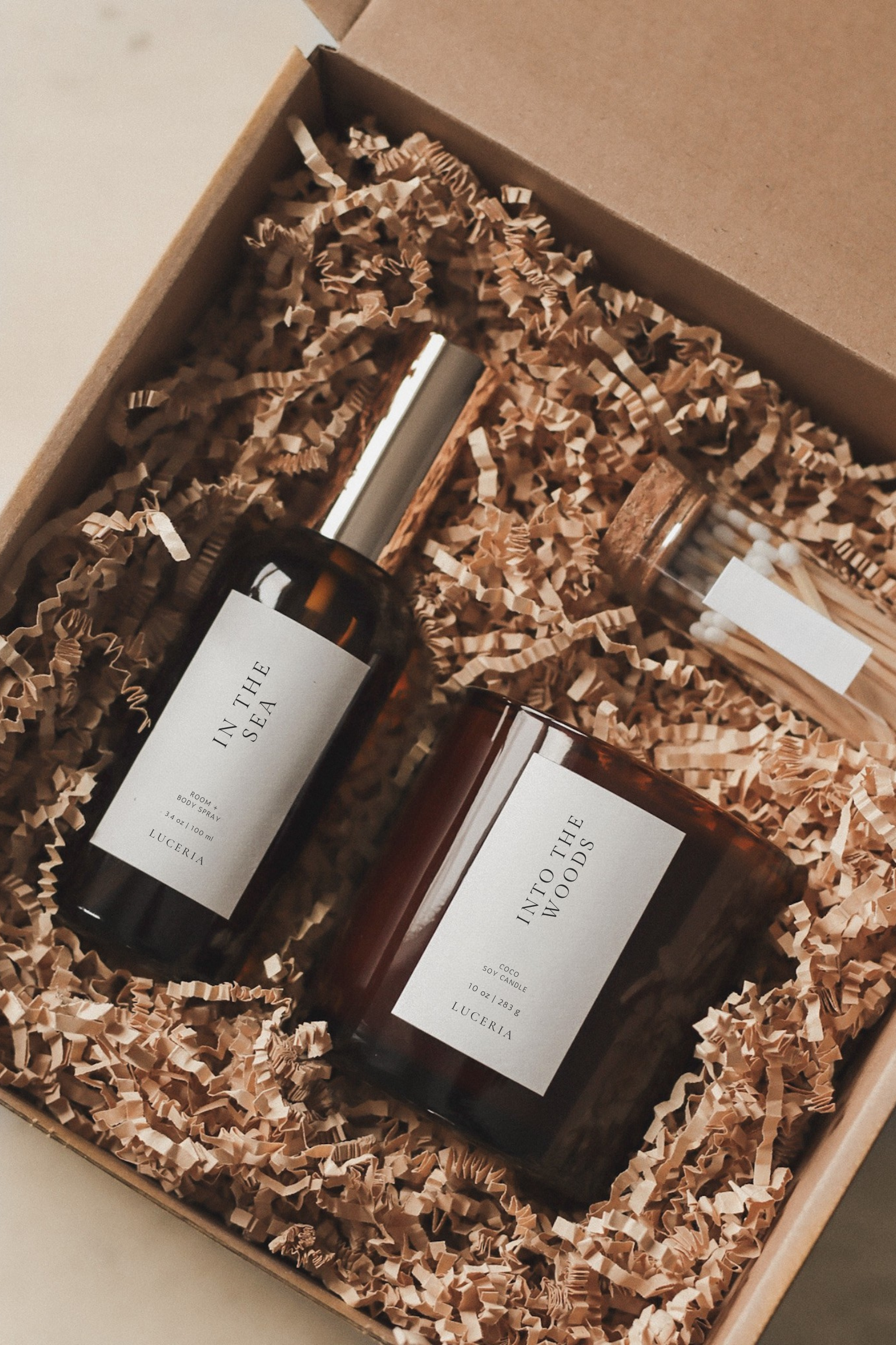 Two bottles of 'In the Woods' perfume in a box with shredded paper