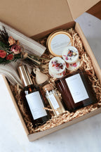 Gifting box with candle products and decorative items in brown Kraft box.