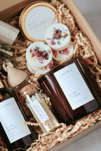 Gift set with candles, bottles, and bath bombs in a decorative box.