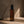 Ember Palo Santo + Sandalwood room and linen spray by Luceria beside smoking incense on a textured beige surface with warm natural light.