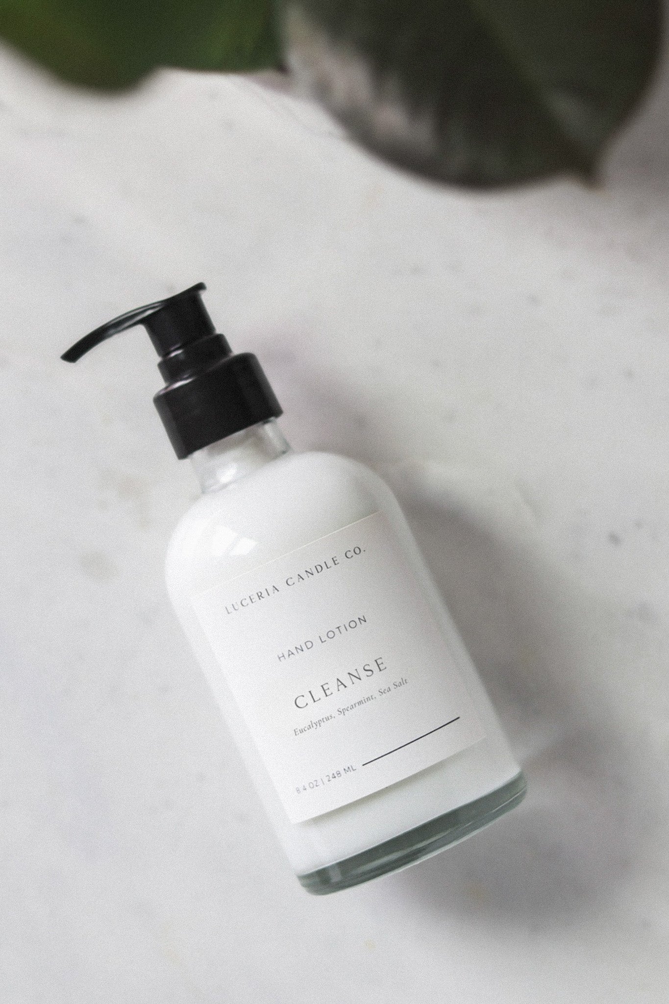 Hand lotion bottle labeled 'Cleanse' on a light surface with a blurred background