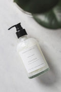 Hand soap bottle labeled 'Cleanse' on a marble surface