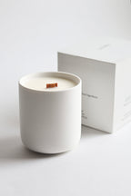 White ceramic candle with a Luceria product box on off-white background