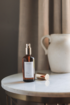 Brown Luceria Candle Co. bottle with a label on a marble surface with a neutral background