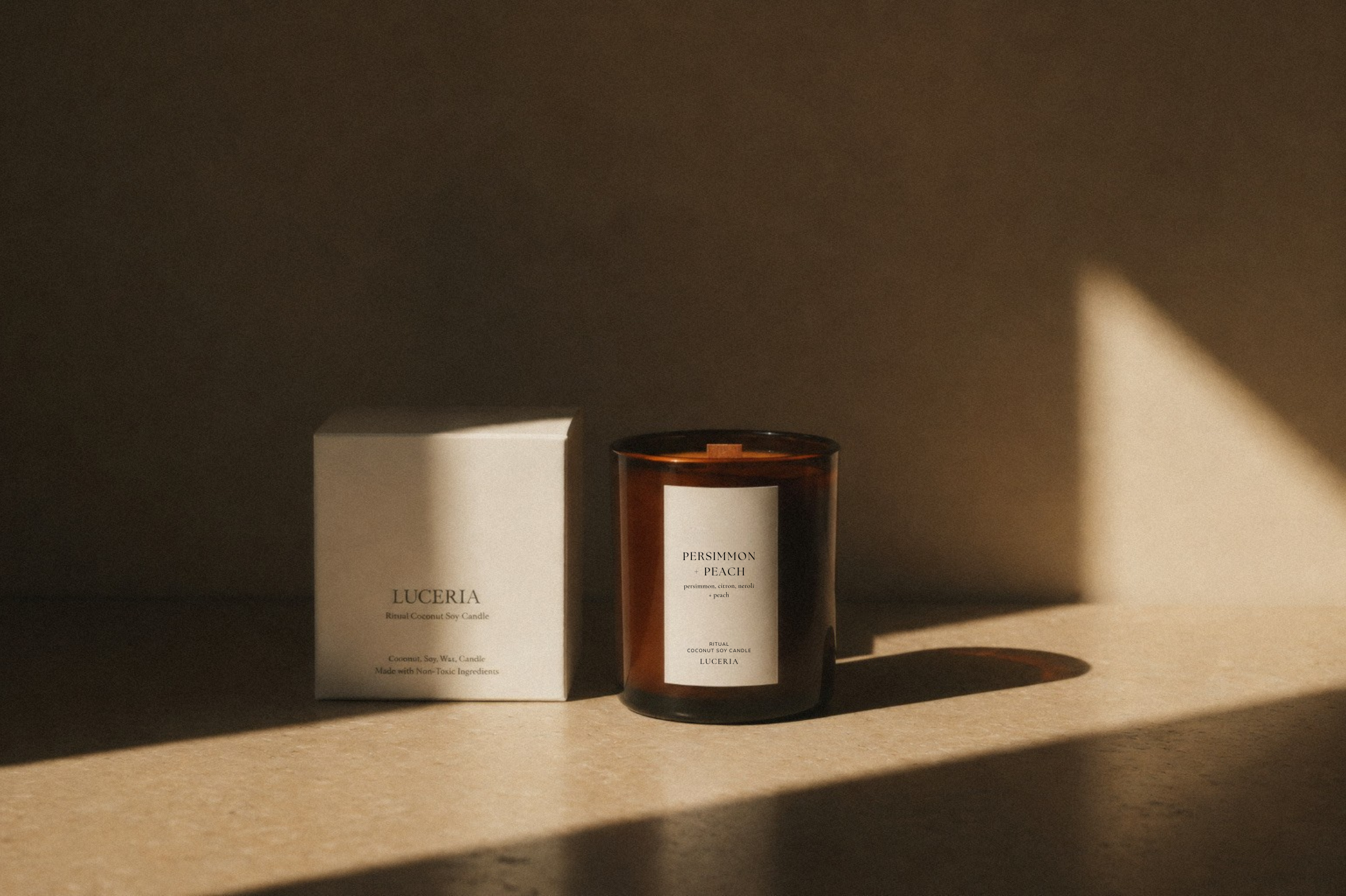 persimmon citron scented candle by luceria candle co in a neutral background with branded box