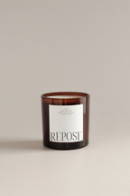 Lavender vanilla scented candle with 'Repose' label on a beige background