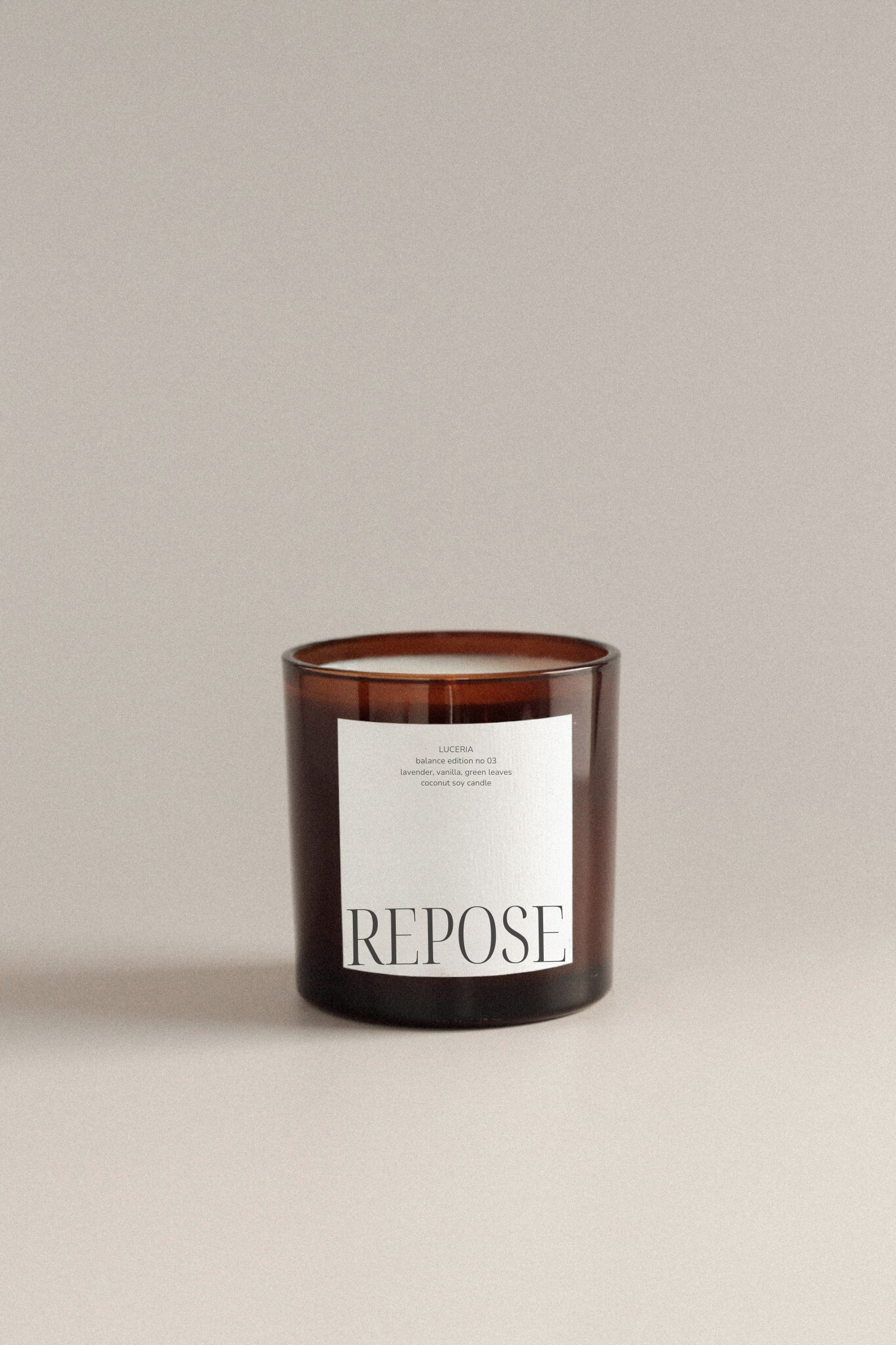 Lavender vanilla scented candle with 'Repose' label on a beige background