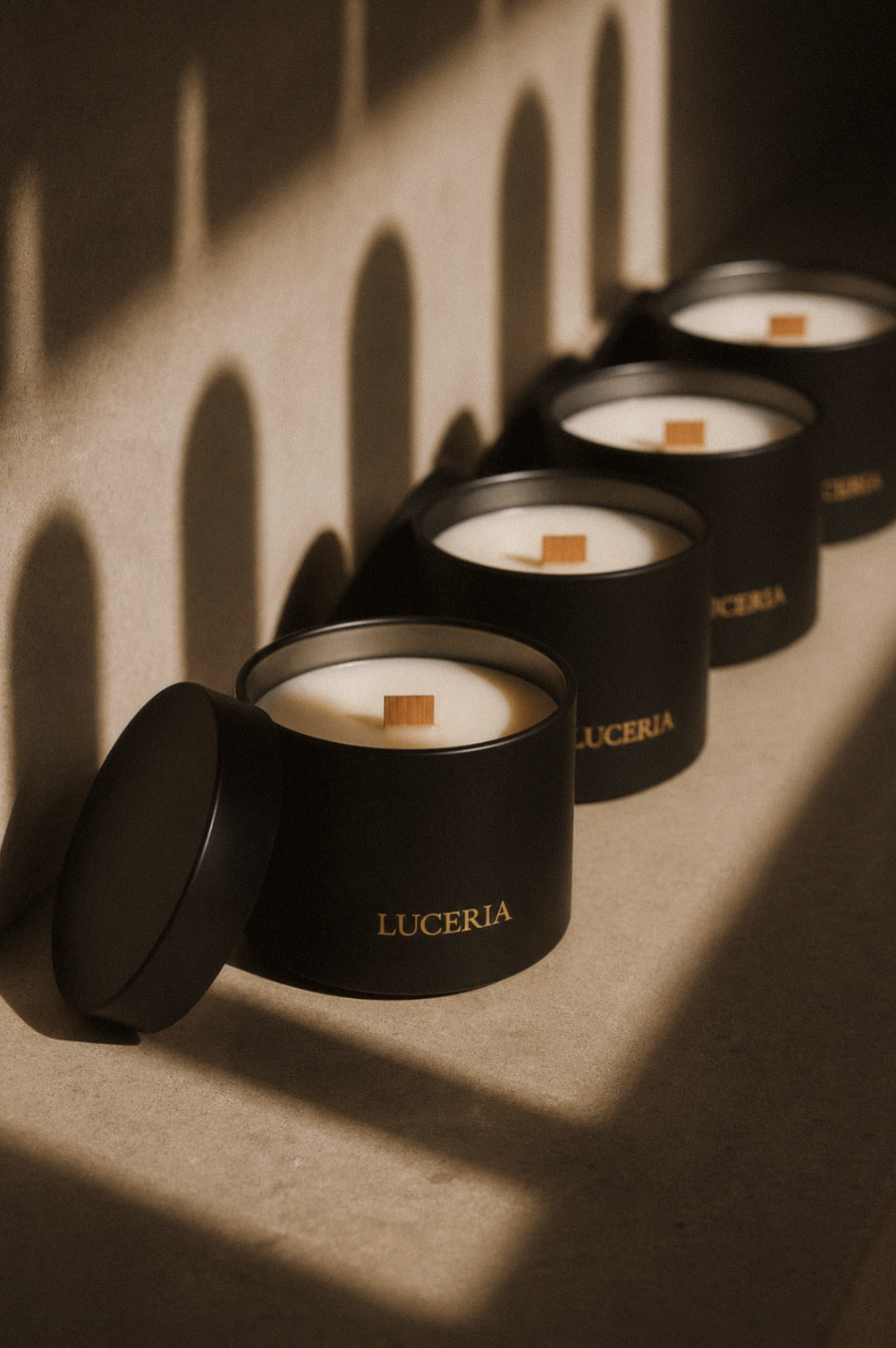 A row of black candles with luceria branding in a sunset neutral background