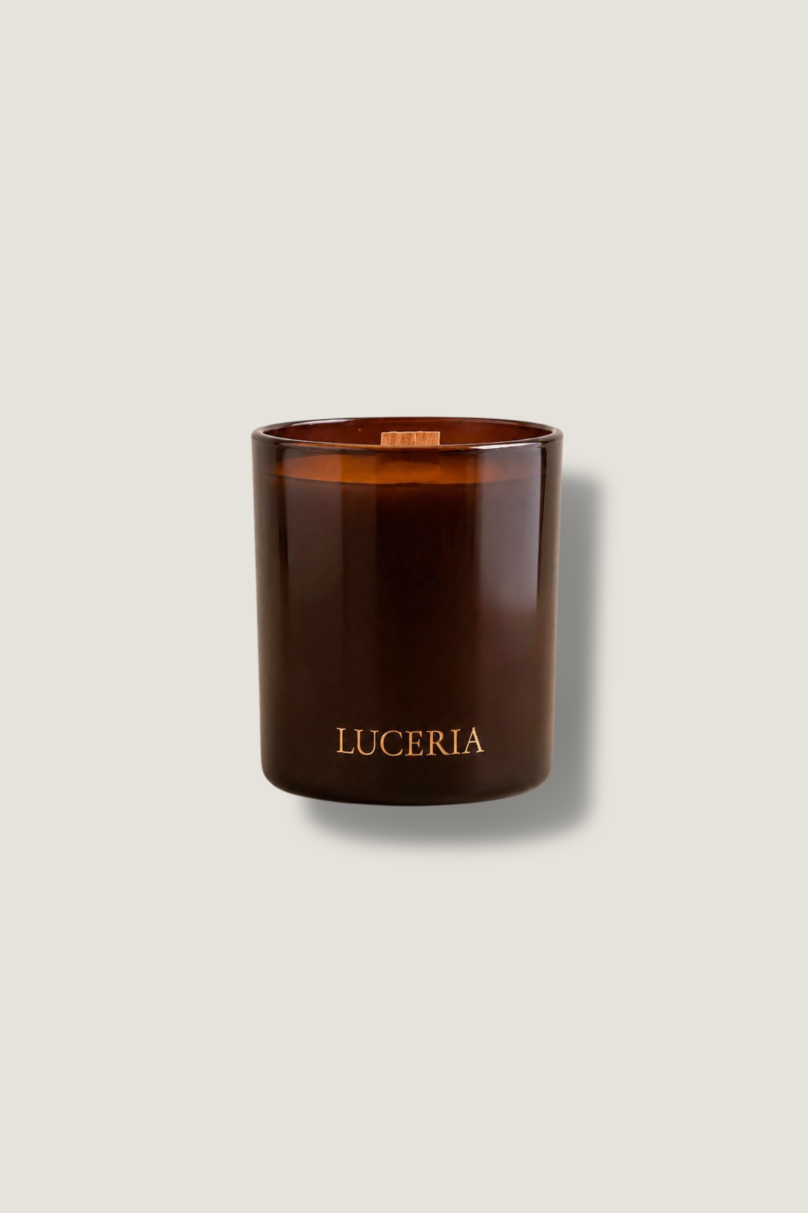 Brown amber candle with 'LUCERIA' branding on a light gray background